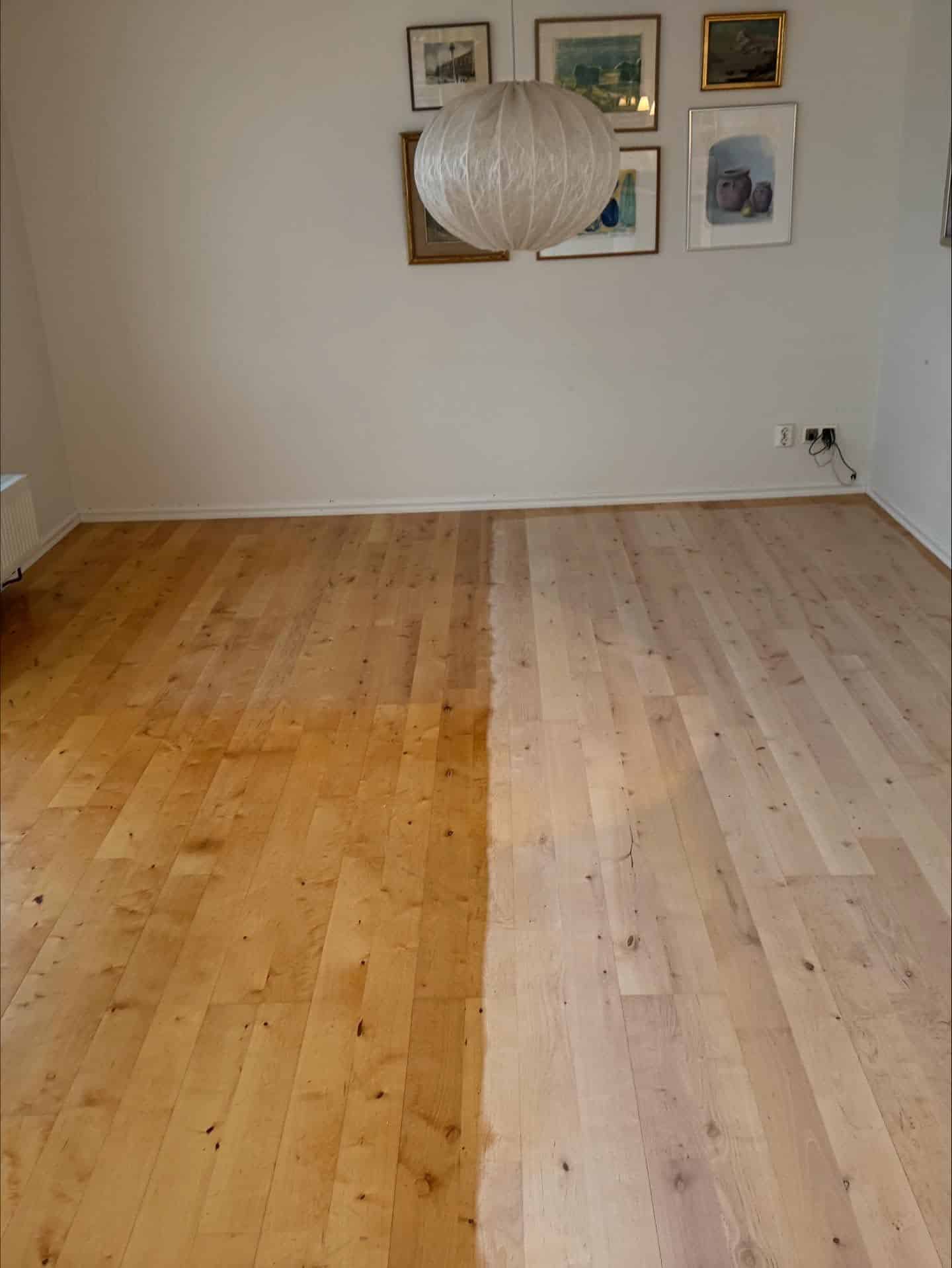 Pågående golvslipning av björkparkett där skillnaden mellan gulnat golv och nyslipad ljus yta syns tydligt.
