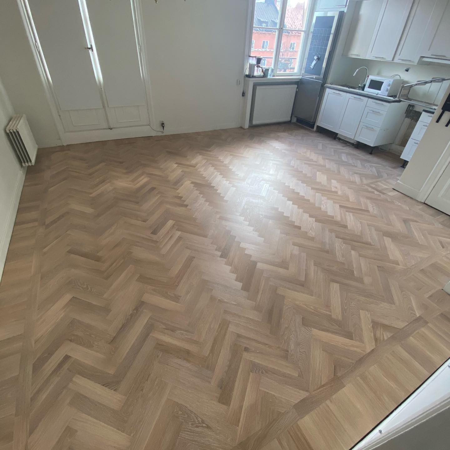 Färdiglagt fiskbensgolv i massiv ek i ljus och modern lägenhet i Stockholm, behandlat med Ciranova UN1CO Natural White.