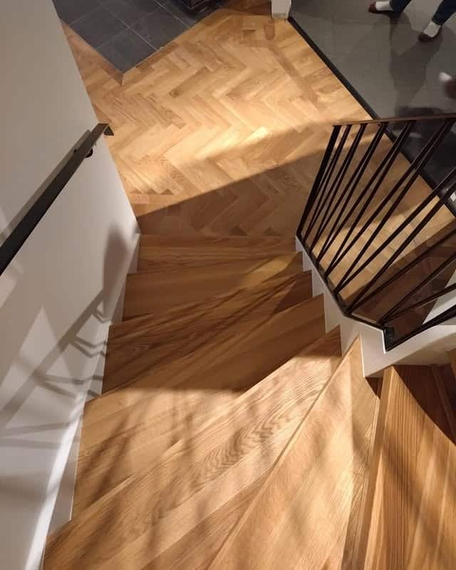 Fiskbensparkett i ek med fris och hårdvaxolja som möter trappa med nya eksteg i samma träslag.
